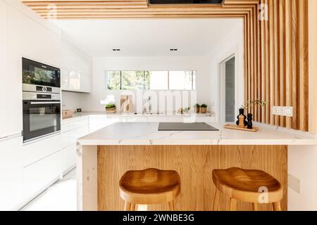 Ein Bild einer offenen Küche mit Holzelementen und Marmorbar in einer mediterranen Villa Stockfoto