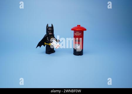 Ein Lego Batman, isoliert vor einem leeren blauen Hintergrund Stockfoto