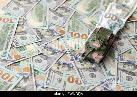 Tank auf zerknitterten 100-Dollar-Banknoten. Hintergrund der Kriegsfinanzierung und des militärischen Unterstützungspreises für die Vereinigten Staaten von Amerika Stockfoto