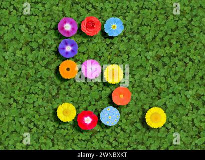 Nummer geschrieben mit bunten Blumen auf grünem Kleeblatt Hintergrund Stockfoto