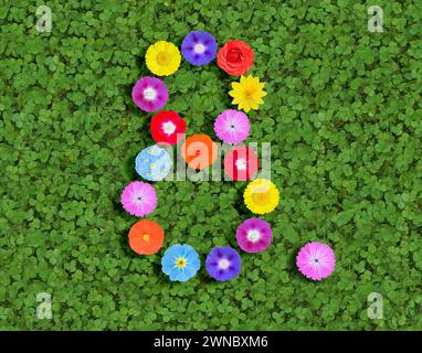 Nummer geschrieben mit bunten Blumen auf grünem Kleeblatt Hintergrund Stockfoto