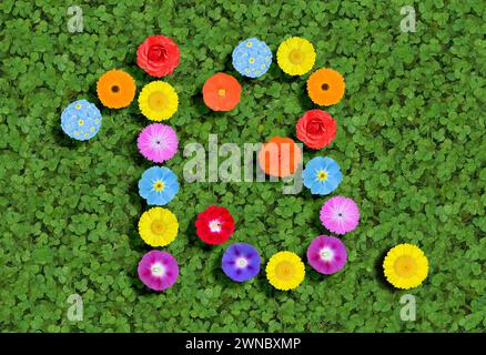 Nummer geschrieben mit bunten Blumen auf grünem Kleeblatt Hintergrund Stockfoto
