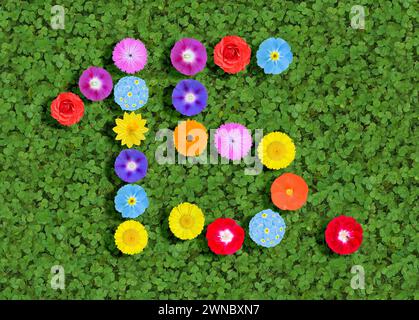 Nummer geschrieben mit bunten Blumen auf grünem Kleeblatt Hintergrund Stockfoto