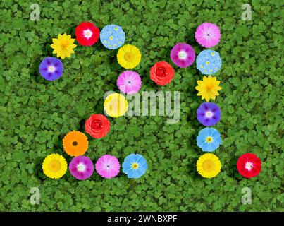 Nummer geschrieben mit bunten Blumen auf grünem Kleeblatt Hintergrund Stockfoto