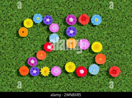 Nummer geschrieben mit bunten Blumen auf grünem Kleeblatt Hintergrund Stockfoto