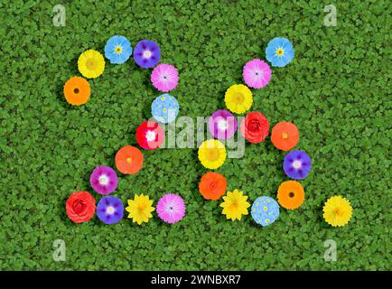 Nummer geschrieben mit bunten Blumen auf grünem Kleeblatt Hintergrund Stockfoto