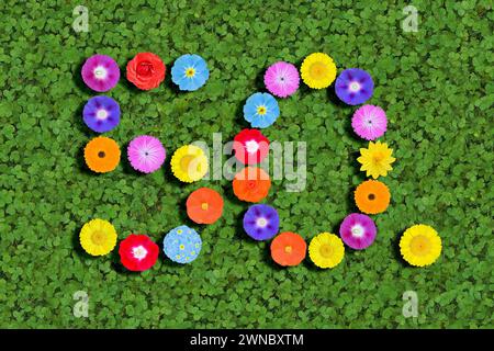 Nummer geschrieben mit bunten Blumen auf grünem Kleeblatt Hintergrund Stockfoto