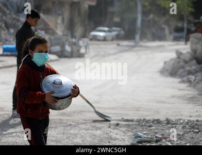 Gaza. März 2024. Ein Mädchen mit einem Topf wird am 1. März 2024 auf einer Straße in Rafah im südlichen Gazastreifen gesehen. Mehr als 30.000 Palästinenser in Gaza sind seit Donnerstag an israelischen Angriffen gestorben, während sich die humanitäre Krise in der palästinensischen Enklave verschärft hat. Quelle: Yasser Qudih/Xinhua/Alamy Live News Stockfoto