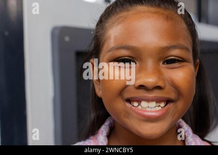 Birassisches Mädchen mit einem hellen Lächeln, ein farbenfrohes Oberteil in einer Schulklasse Stockfoto