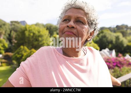 Ältere Frau mit kurzen grauen Haaren blickt nachdenklich in einer Umgebung im Freien Stockfoto