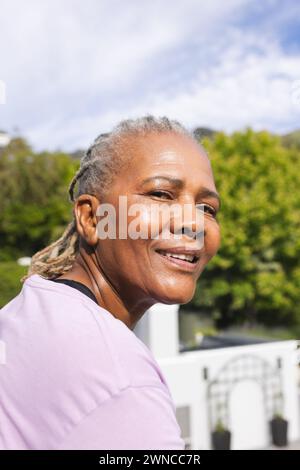 Eine ältere Frau mit grauen Haaren lächelt draußen Stockfoto