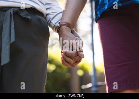 Ein hochrangiges birassisches Paar hält die Hände und zeigt ein Band von Komfort und Zuneigung Stockfoto