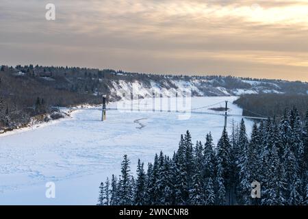 Blick auf die Fort Edmonton Foot Bridge im Winter mit redischem Sonnenuntergang auf der Ostseite Stockfoto