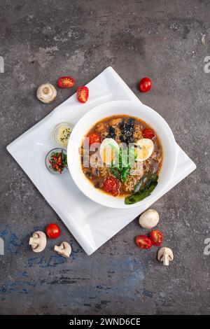 Eine Dampfschale mit traditionellen japanischen Ramen, gefüllt mit herzhafter Brühe, federnden Nudeln und einer Auswahl an frischem Gemüse und zartem Gemüse Stockfoto