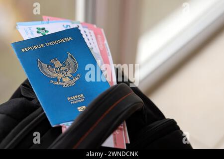 Blue Republic Indonesien Pass mit Geld und Flugtickets auf touristischen Rucksack Nahaufnahme. Tourismus und Reisekonzept Stockfoto