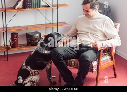 Porträt eines älteren schwarz-weißen Kurzzeigers, der einem lächelnden glücklichen Besitzer eine Pfote gibt. Grenzenlose Freundschaft und Hingabe. Stockfoto