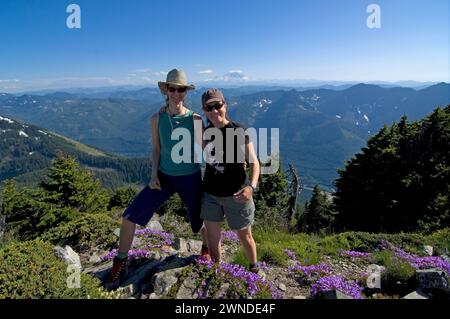 Wanderer Mt Defiance und Cascade erstrecken sich über Davidson's Penstemon Penstemon davidsonii Wildblumen in voller Blüte Cascades Washington State USA Stockfoto