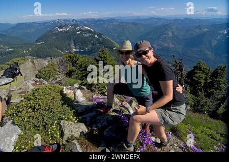 Wanderer Mt Defiance und Cascade erstrecken sich über Davidson's Penstemon Penstemon davidsonii Wildblumen in voller Blüte Cascades Washington State USA Stockfoto