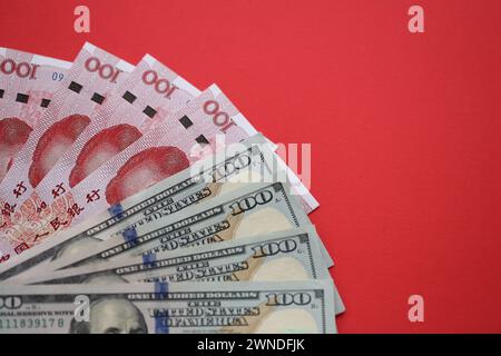 Viele Geldscheine der Volksrepublik China und der Vereinigten Staaten. PRC Yuan- und USD-Dollar-Banknoten aus nächster Nähe Stockfoto