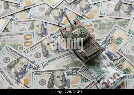 Tank auf zerknitterten 100-Dollar-Banknoten. Hintergrund der Kriegsfinanzierung und des militärischen Unterstützungspreises für die Vereinigten Staaten von Amerika Stockfoto