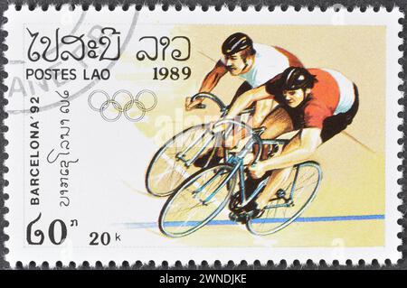 Gestempelte Briefmarke von Laos, die Radfahren, Olympische Sommerspiele 1992 - Barcelona, um 1989 zeigt. Stockfoto