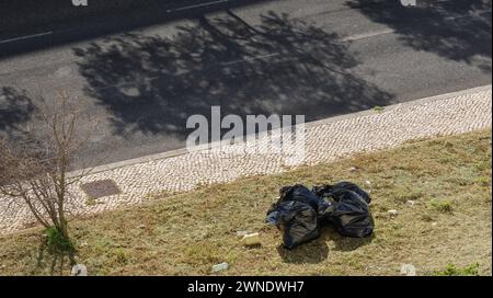 Müllsack, der neben einer Straße steht, verursacht Verschmutzung im Garten Stockfoto