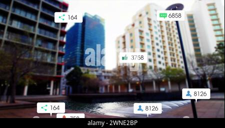 Bild von Social-Media-Symbolen und Zahlen auf weißen Transparenten über der Stadtlandschaft Stockfoto