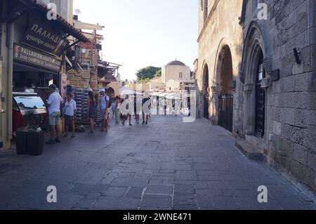 Touristen gehen durch die Straßen des mittelalterlichen Stadtzentrums von Rhodos Altstadt, Griechenland Stockfoto