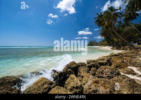 Einladendes kristallklares Meer und schäumende Brandung, die sanft auf dem wunderschönen weichen Sand von Rockley Beach, Barbados, schlängelt. Stockfoto