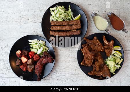 Tandoori gemischter Grill, Hühnchen Tandoori und Lammkebabs - indische Gerichte mit gewürztem Fleisch Stockfoto