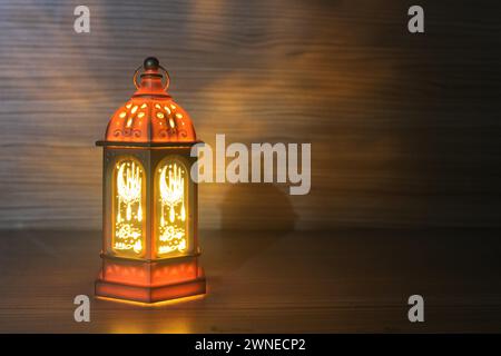 Ornamentale arabische Laterne mit brennender Kerze, die nachts leuchtet. Festliche Grußkarte, Einladung zum muslimischen heiligen Monat Ramadan Kareem. Stockfoto