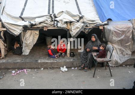 Rafah, Gaza. Februar 2024. Die vertriebene palästinensische Familie sitzt am Samstag, den 2. März 2024, vor einem provisorischen Zelt an einer Schule, in der Familien aus anderen Teilen des Gazastreifens im Flüchtlingslager Rafah im südlichen Gaza-Streifen untergebracht sind. Während der anhaltenden Kämpfe zwischen Israel und den Zehnten Palästinensern, die im gesamten Gazastreifen großen Hunger verursachten. 10 Kinder sind in Gaza-Krankenhäusern an Unterernährung und Dehydration gestorben, sagte der Sprecher der UN-Weltgesundheitsorganisation Christian Lindmeier. Foto: Ismael Mohamad/UPI Credit: UPI/Alamy Live News Stockfoto