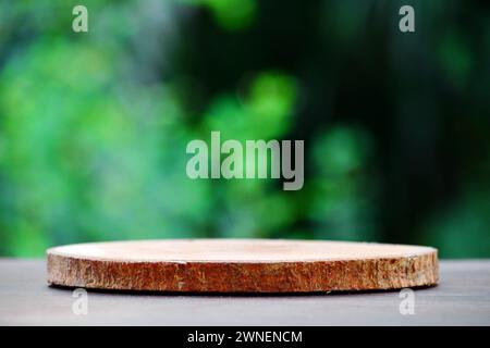 Leere runde Warentabelle aus Holz zylindrische runde geometrische Form. Umweltfreundlicher und minimalistischer Stil mit verschwommenem Gartenhintergrund und natürlichem V Stockfoto