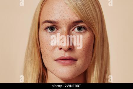 Close-up-Atelierporträt einer blonden Frau mit Sommersprossen. Abgeschnittene Aufnahme einer Frau mit glatter Haut. Sehr detailreiches Bild einer jungen Frau mit Perfect Stockfoto