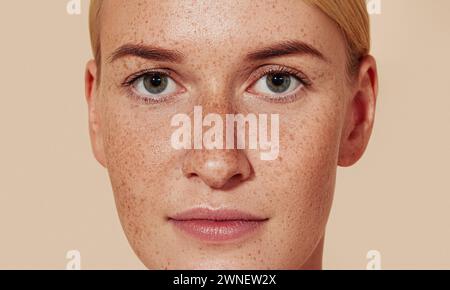 Close-up-Studio-Aufnahme einer jungen Frau mit Sommersprossen. Porträt einer natürlichen Schönheit Frau mit glatter Haut vor pastellfarbenem Hintergrund. Nahaufnahme im Studio Stockfoto