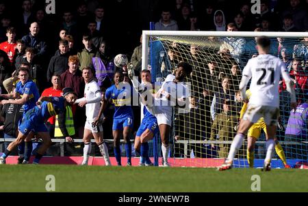 Milton Keynes Dons' Ellis Harrison (Mitte) versucht im Cherry Red Records Stadium in Wimbledon einen Rückschuss auf das Tor. Bilddatum: Samstag, 2. März 2024. Stockfoto