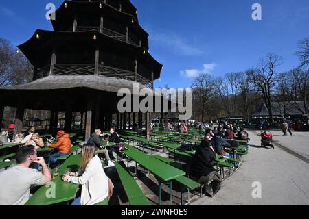 München, Deutschland. März 2024. Besucher sitzen am Chinesischen Turm im Englischen Garten und genießen die warmen Temperaturen und den Sonnenschein. Quelle: Felix Hörhager/dpa/Alamy Live News Stockfoto