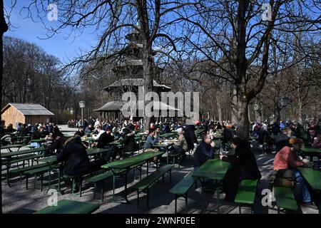 München, Deutschland. März 2024. Besucher sitzen im Biergarten am Chinesischen Turm im Englischen Garten und genießen die warmen Temperaturen und den Sonnenschein. Quelle: Felix Hörhager/dpa/Alamy Live News Stockfoto