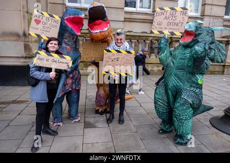 Demonstranten verkleideten sich als Dinosaurier gegen Schnitte in den Künsten mit dem lokalen Dichter Spoz bei der Demonstration Stand Up for Public Services gegen Kürzungen des Stadtrates von Birmingham am 2. März 2024 in Birmingham, Großbritannien. Der Protest ruft Einwohner, Arbeiter und Gewerkschaften in der ganzen Stadt auf, sich gegen verheerende Kürzungen des rates zu versammeln, die derzeit etwa 376 Millionen Pfund für Dienstleistungen betragen, die wahrscheinlich große Auswirkungen auf die Bewohner haben werden. Zu den Bereichen, in denen Kürzungen vorgenommen werden sollen, gehören Jugenddienste, Verkehr, Müllsammlungen, Bibliotheken und Kunstorganisationen. Der von der Labour-Partei betriebene rat ha Stockfoto