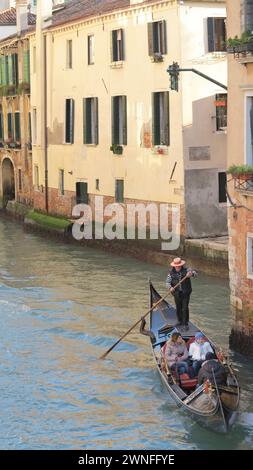 Venedig, Italien - 29. dezember 2012 - Gondoliere nimmt ein Paar in einer Gondel entlang eines romantischen Kanals von Venedig mit. Stockfoto