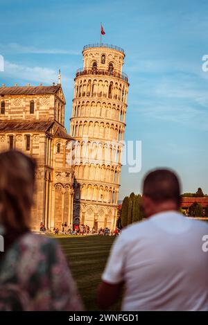 Sehen Sie vorbei an zwei Personen zum Schiefen Turm von Pisa in der goldenen Abendsonne, Toskana, Italien Stockfoto