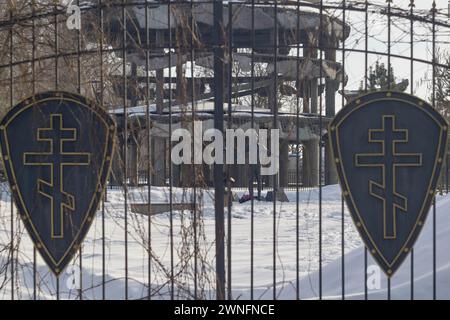 Woronesch, Russland. Februar 2024. Schilde mit Kreuzen sind an den Toren der Kirche und das Rotunde-Denkmal eines sowjetischen Soldaten zu sehen. Ende Februar bis Anfang März kam die Frühlingswärme in die über Millionen große Stadt Zentralrusslands, Woronesch. Schlamm und Pfützen hinderten Woronesch nicht daran, Wahlkampfschilder auf den Straßenbrettern zu sehen. Die Präsidentschaftswahlen in der Russischen Föderation sind für den 17. März geplant. Vier Kandidaten nehmen an den Wahlen Teil, von denen drei die Politik des derzeitigen Präsidenten Wladimir Putin voll unterstützen. Und das vierte ist t Stockfoto