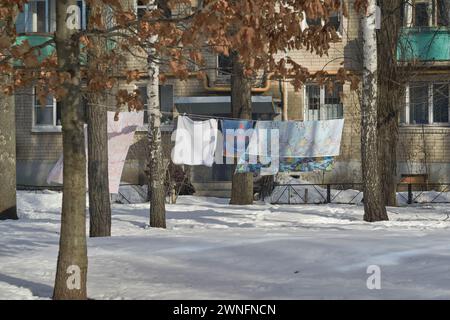 Woronesch, Russland. Februar 2024. Blick auf gewaschene Kleidung im Innenhof eines Wohngebäudes. Ende Februar bis Anfang März kam die Frühlingswärme in die über Millionen große Stadt Zentralrusslands, Woronesch. Schlamm und Pfützen hinderten Woronesch nicht daran, Wahlkampfschilder auf den Straßenbrettern zu sehen. Die Präsidentschaftswahlen in der Russischen Föderation sind für den 17. März geplant. Vier Kandidaten nehmen an den Wahlen Teil, von denen drei die Politik des derzeitigen Präsidenten Wladimir Putin voll unterstützen. Und der vierte ist der derzeitige Präsident. Die Stockfoto