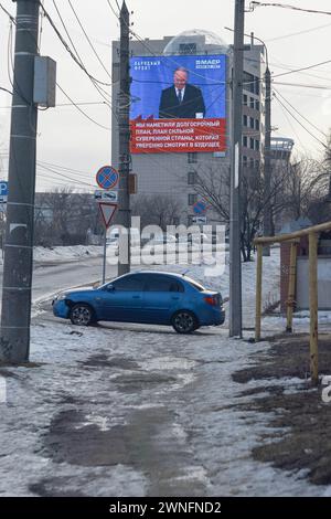 Woronesch, Russland. Februar 2024. Übertragung der Rede von Präsident Wladimir Putins auf dem Stadtanzeiger im Bereich des Pädagogischen Instituts. Ende Februar bis Anfang März kam die Frühlingswärme in die über Millionen große Stadt Zentralrusslands, Woronesch. Schlamm und Pfützen hinderten Woronesch nicht daran, Wahlkampfschilder auf den Straßenbrettern zu sehen. Die Präsidentschaftswahlen in der Russischen Föderation sind für den 17. März geplant. Vier Kandidaten nehmen an den Wahlen Teil, von denen drei die Politik des derzeitigen Präsidenten Wladimir Putin voll unterstützen. Und das fo Stockfoto