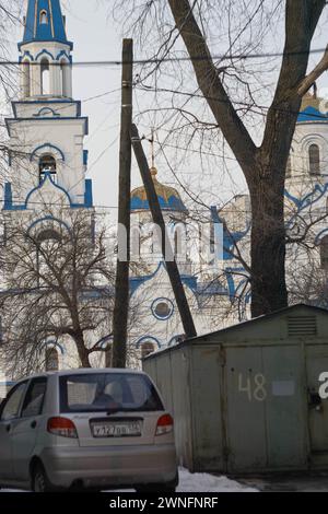 Woronesch, Russland. Februar 2024. Blick auf den Tempel von einem Wohnhof mit privater Garage. Ende Februar bis Anfang März kam die Frühlingswärme in die über Millionen große Stadt Zentralrusslands, Woronesch. Schlamm und Pfützen hinderten Woronesch nicht daran, Wahlkampfschilder auf den Straßenbrettern zu sehen. Die Präsidentschaftswahlen in der Russischen Föderation sind für den 17. März geplant. Vier Kandidaten nehmen an den Wahlen Teil, von denen drei die Politik des derzeitigen Präsidenten Wladimir Putin voll unterstützen. Und der vierte ist der derzeitige Präsident. Das Centra Stockfoto