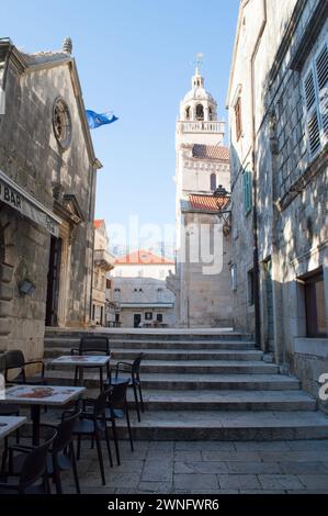 Korčula, Kroatien - 22. April 2023: Enge Straße mit Treppen, die zur Markuskirche in Korcula, Kroatien, führen Stockfoto