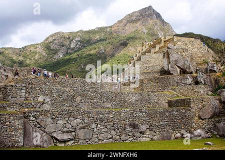 Machu Picchu, Cuzco, Peru - 12. juli 2008 - Touristen schlendern durch die antike Inka-Stadt Machu Picchu. UNESCO-Weltkulturerbe. Stockfoto