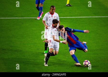 MESSI, DRIBBLE, BARCELONA FC, 2017: Lionel Messi fährt vorwärts und dribbelt durch die Verteidigung von Sevilla, um unter dem Druck von Nicolás Pareja eine Schießchance zu schaffen. Barcelona FC gegen Sevilla FC in Camp Nou, Barcelona am 5. April 2017. Foto: Rob Watkins. Barca gewann das Spiel 3-0 mit drei Toren in den ersten 33 Minuten. Das Spiel wurde in einer Regenflut während eines massiven Frühlingssturms ausgetragen. Stockfoto