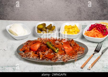 iskender Kebab. Traditionelle türkische Küche mit Tomatensauce und Butter. iskender Döner auf grauem Hintergrund Stockfoto