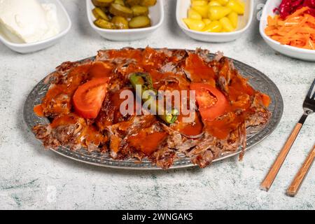 iskender Kebab. Traditionelle türkische Küche mit Tomatensauce und Butter. iskender Döner auf grauem Hintergrund Stockfoto